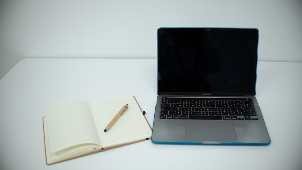 Laptop and notebook used to plan a small business website brief